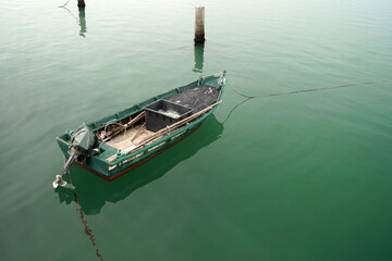 Primo piano di barca su mare calmo e limpido colore verde acqua 