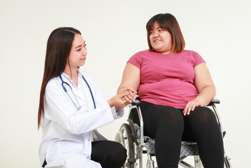 Female doctor treating an obese woman sitting in a wheelchair. Weight loss concept. Health care for...