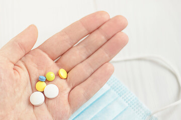 multicolored pills on a woman's palm