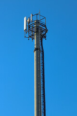 Telecommunication tower of 4G and 5G cellular. Macro Base Station. 5G radio network telecommunication equipment with radio modules and smart antennas mounted on a metal. Blue sky in the background.