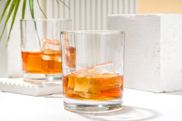 Alcoholic drink, cold summer hard strong alcohol cocktail, whiskey with ice in short glasses on white background