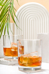 Alcoholic drink, cold summer hard strong alcohol cocktail, whiskey with ice in short glasses on white background