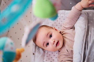 Baby playing with musical crib mobile