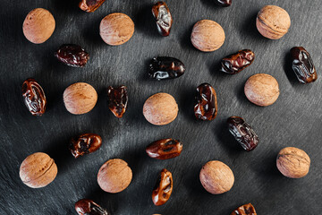 Fototapeta na wymiar dates and walnuts on a black background. Healthy eating