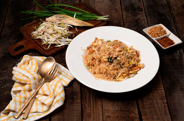 Fried rice noodle Pad thai has egg vegetable on wood table.