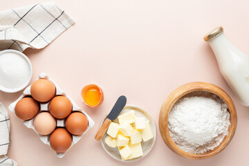 Baking ingredients on beige background. Flour eggs butter sugar and oat milk, ingredients for making a cake, cookies or pastry. Top view copy space