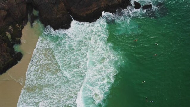 Aerial view of Praia da Joatinga, a paradise in Rio de Janeiro, Brazil. Sunny day with some clouds in the morning. Sea with good waves for surfers. Greenish sea. Drone take.