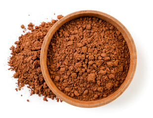 Cocoa powder in a wooden plate and scattered on a white background. Top view