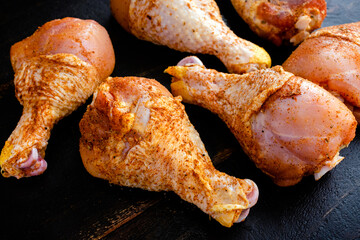 Raw Chicken Drumsticks Rubbed in Spices: Uncooked chicken legs dusted with paprika and other spices