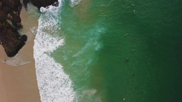 Aerial view of Praia da Joatinga, a paradise in Rio de Janeiro, Brazil. Sunny day with some clouds in the morning. Sea with good waves for surfers. Greenish sea. Drone take.