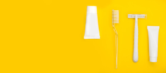 Toothbrush, razor, toothpaste, minimalistic yellow background.