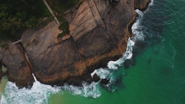 Aerial view of Praia da Joatinga, a paradise in Rio de Janeiro, Brazil. Sunny day with some clouds in the morning. Sea with good waves for surfers. Greenish sea. Drone take.