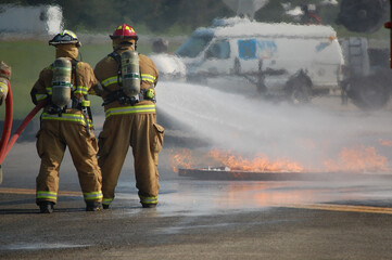 firefighters with hose line and fuel fire