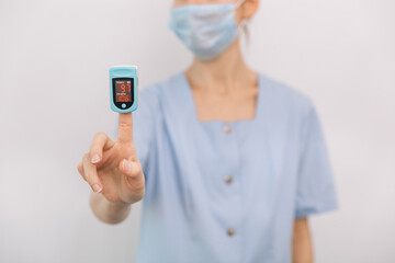 Pulse oximeter with hand of doctor isolated on white. The concept of portable digital device to measure person's oxygen saturation. Measuring oxygen saturation, pulse rate and oxygen levels.