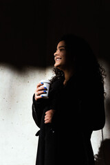 Portrait of a pretty young girl with curly hair in elegant clothes outdoors