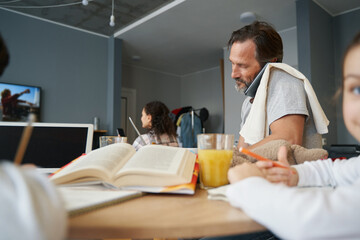 Obraz premium Man talking on phone from home while working at table