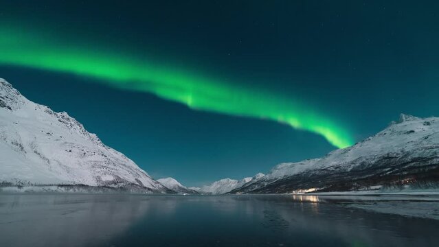 Northern lights over the fjord and mountains with a reflection in the water. Aurora Borealis Scandinavia in Northern Norway. High quality 4k footage