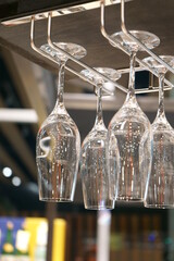 Wine glasses hanging from a glass holder.