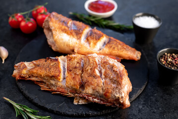 grilled red sea bass with rosemary and spices on a stone background 
