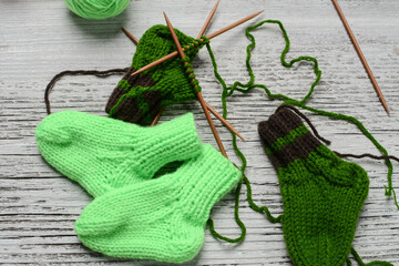 Messy knitters table, yarn and small baby socks on it