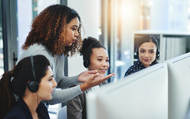 Customer satisfaction is a team effort in our department. Shot of a young woman assisting her colleagues in a call centre.