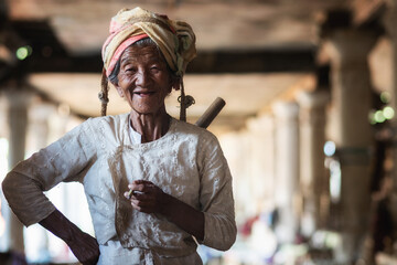 Old Burmese lady smoking a cigar and smiling in Indein Village, Shan State, Myanmar (Burma).	
