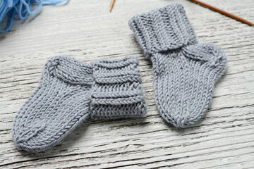 Fototapeta na wymiar Messy knitters table, yarn and small baby socks on it