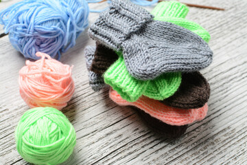 Obraz na płótnie Canvas Messy knitters table, yarn and small baby socks on it