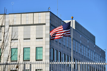 An american flag waves in the wind.  A view of the Embassy of the United States of America in Kyiv, Ukraine