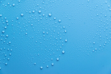 Blue pastel water drops on light shiny surface