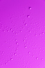Violet pastel water drops on light shiny surface