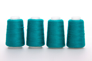Green spool of thread isolated on white background. Skein of woolen threads. Yarn for knitting. Materials for sewing machine. Coil