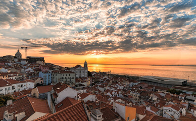 Dramatic sunrise over the rooftops of old district Alfama, Lisbon, Portugal