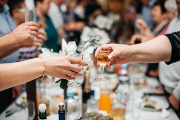 Russian wedding, guests hold glasses with alcohol and are being minted