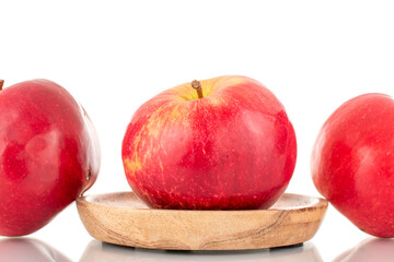 Three ripe red apples with wood saucer, macro, isolated on white background.