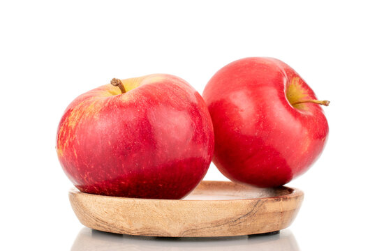 Two ripe red apples with wood saucer, macro, isolated on white background.