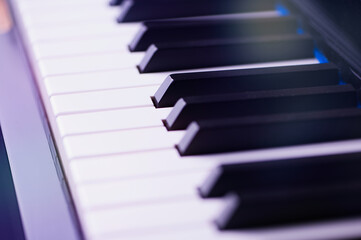 Naklejka premium Macro photo of a piano keyboard with lens flares, small focus field on a black key in the middle