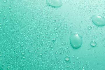 Blue pastel water drops on light shiny surface