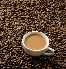 A cup of coffee with milk on a background of coffee beans.
