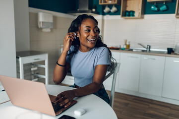 African american woman working from home while using a laptop
