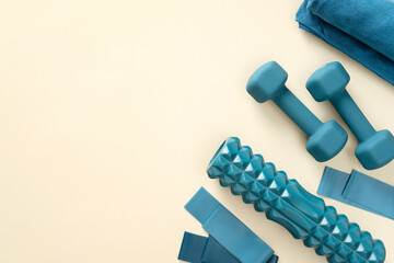 Blue fitness equipment for workout on pastel beige table. Top view.