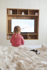Little cute girl watching television at home