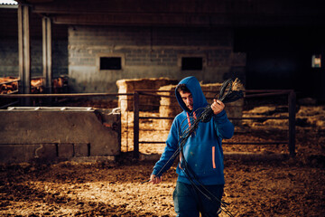 Young farmer untying ropes on his farm