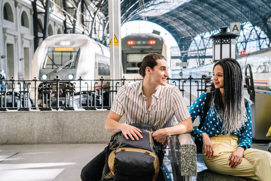 Multiracial couple sitting in railway station