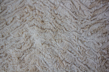 Beige curly soft and artistic fur textured background with waves
