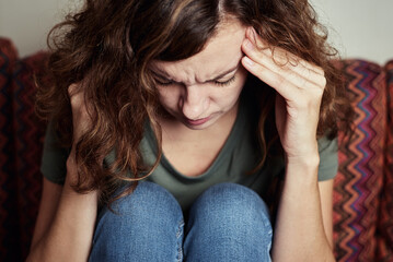 Woman at home feeling strong headache, touching her temples, migraine due to stress and mental burnout