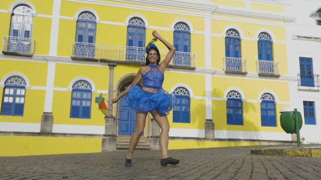 Beautiful Latin dancer dressed up for Carnival on the streets of Olinda. Frevo Recife. Brazil colors. Historical city.