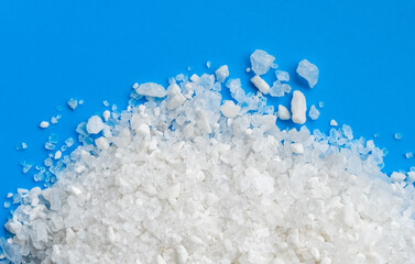 White crystals sea salt top view on blue background.