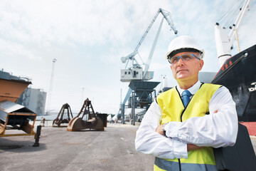 I have my business and i am proud. Portrait of a dock worker standing at the harbor amidst shipping...