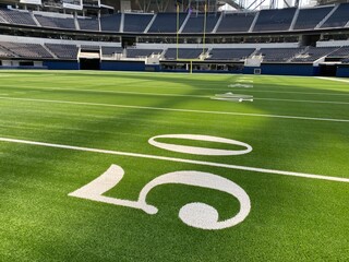 American football field, empty, no crowd with yard line numbers. 50 yard line highlighted.